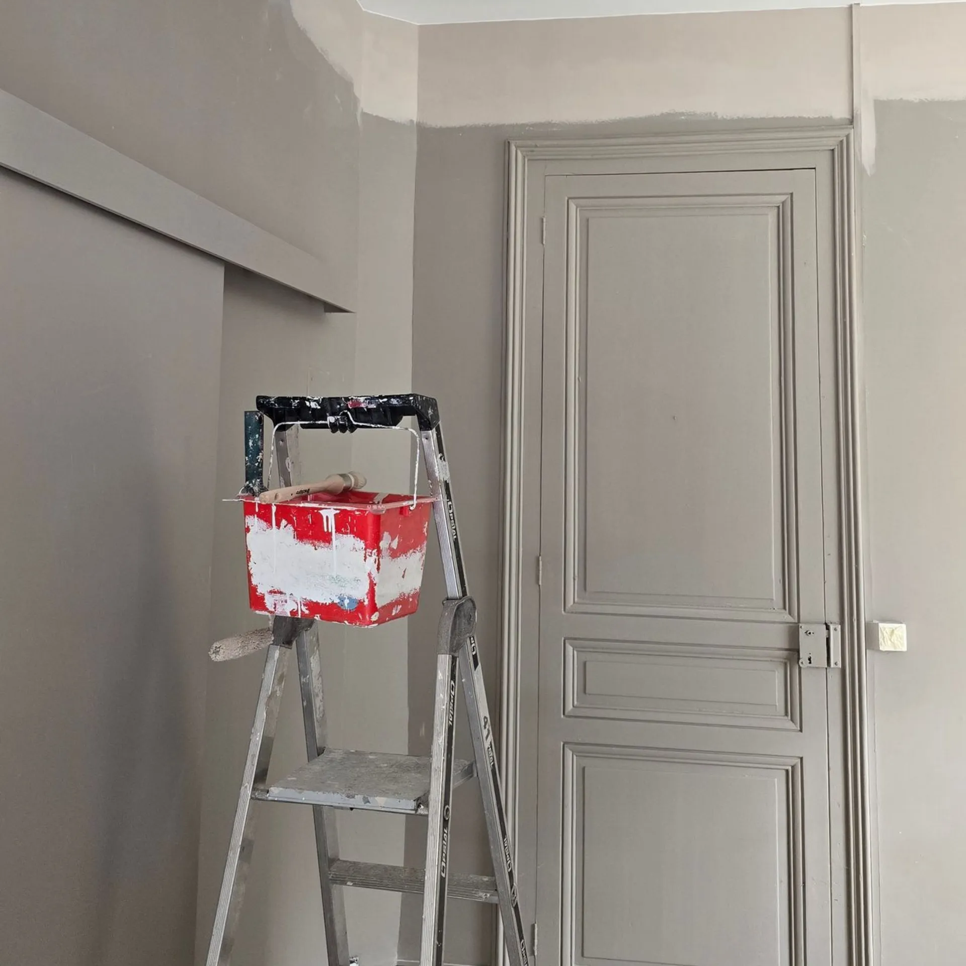 Travaux de peinture intérieure avec murs et moulures rénovés en gris clair