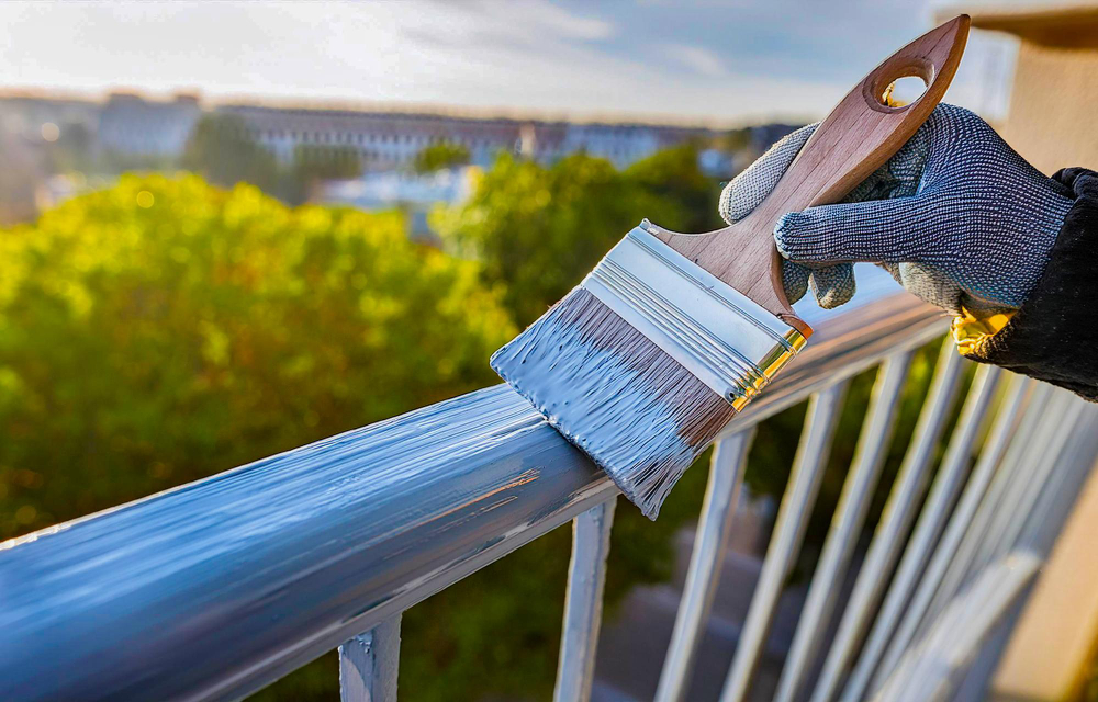 Application de peinture extérieure sur un garde-corps métallique par un artisan
