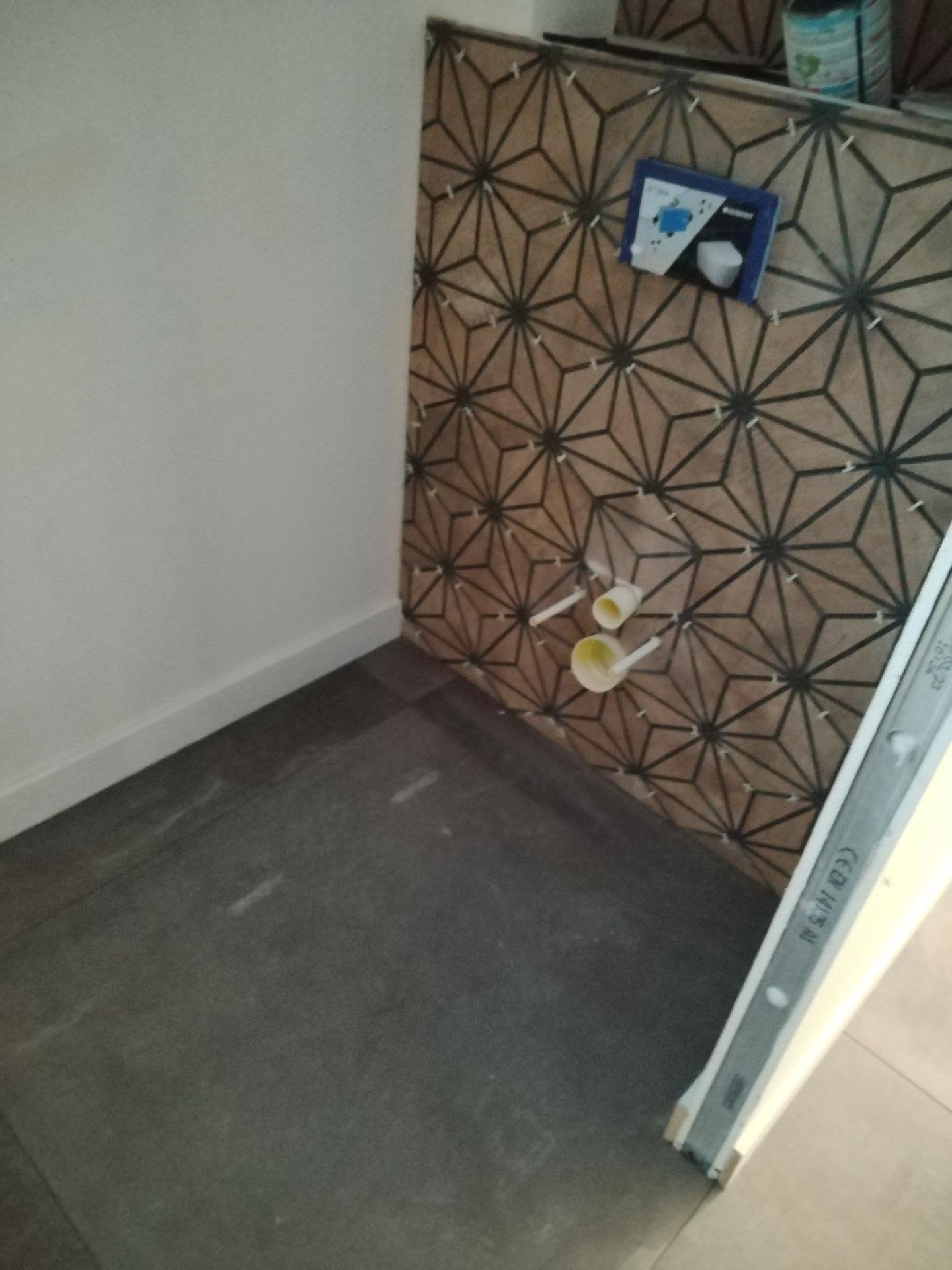 Pose d’un carrelage décoratif à motifs géométriques dans un espace intérieur