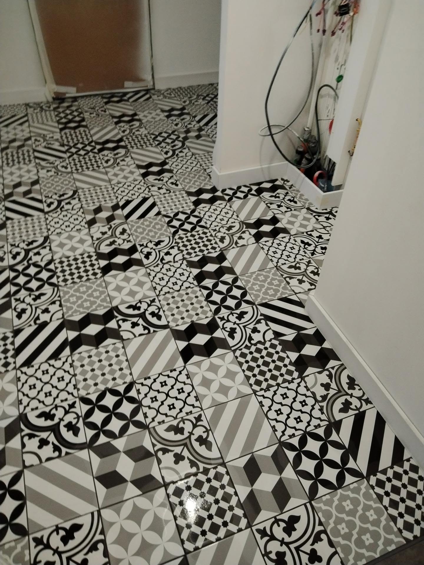 Pose d’un carrelage de sol à motifs géométriques dans une pièce intérieure
